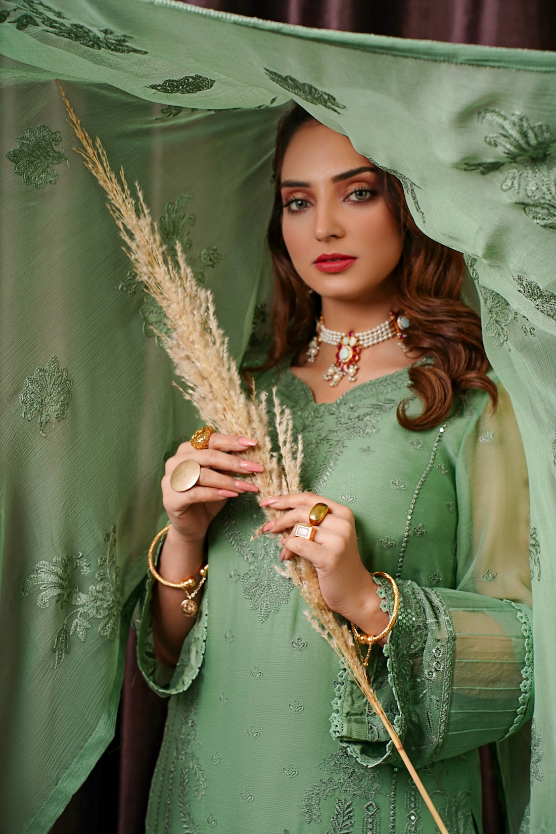 a woman in a green dress holding a plant
