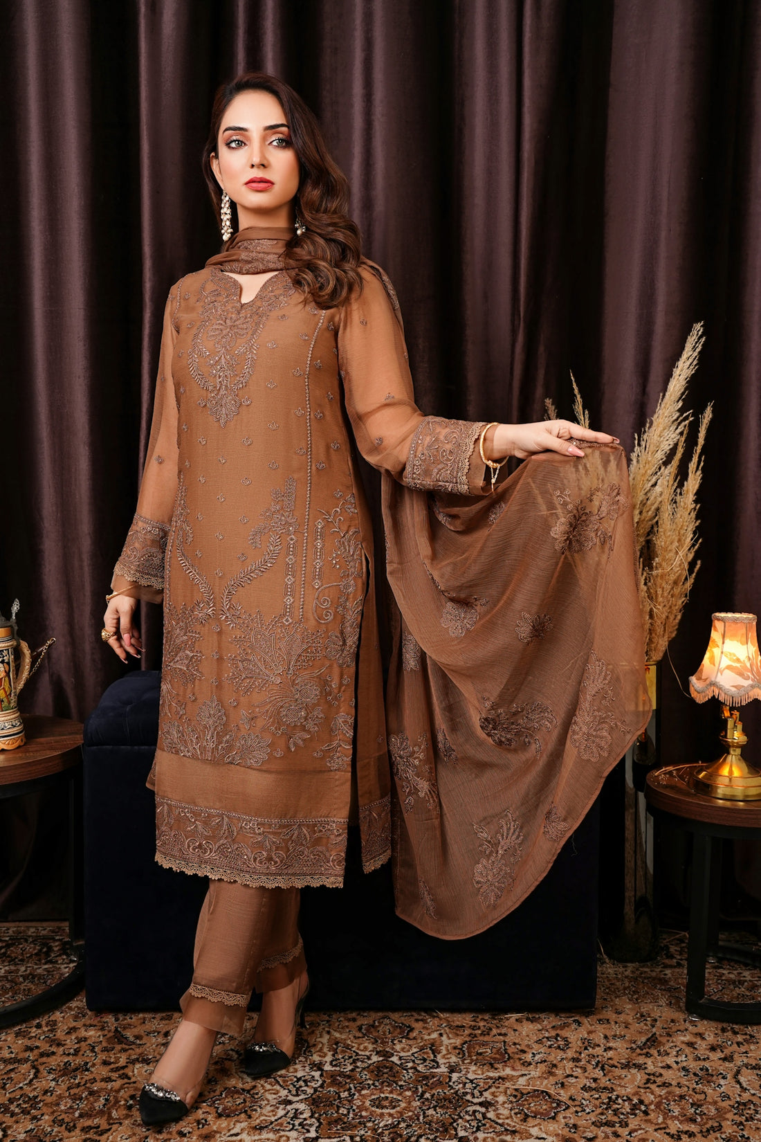 a woman standing in front of a brown curtain