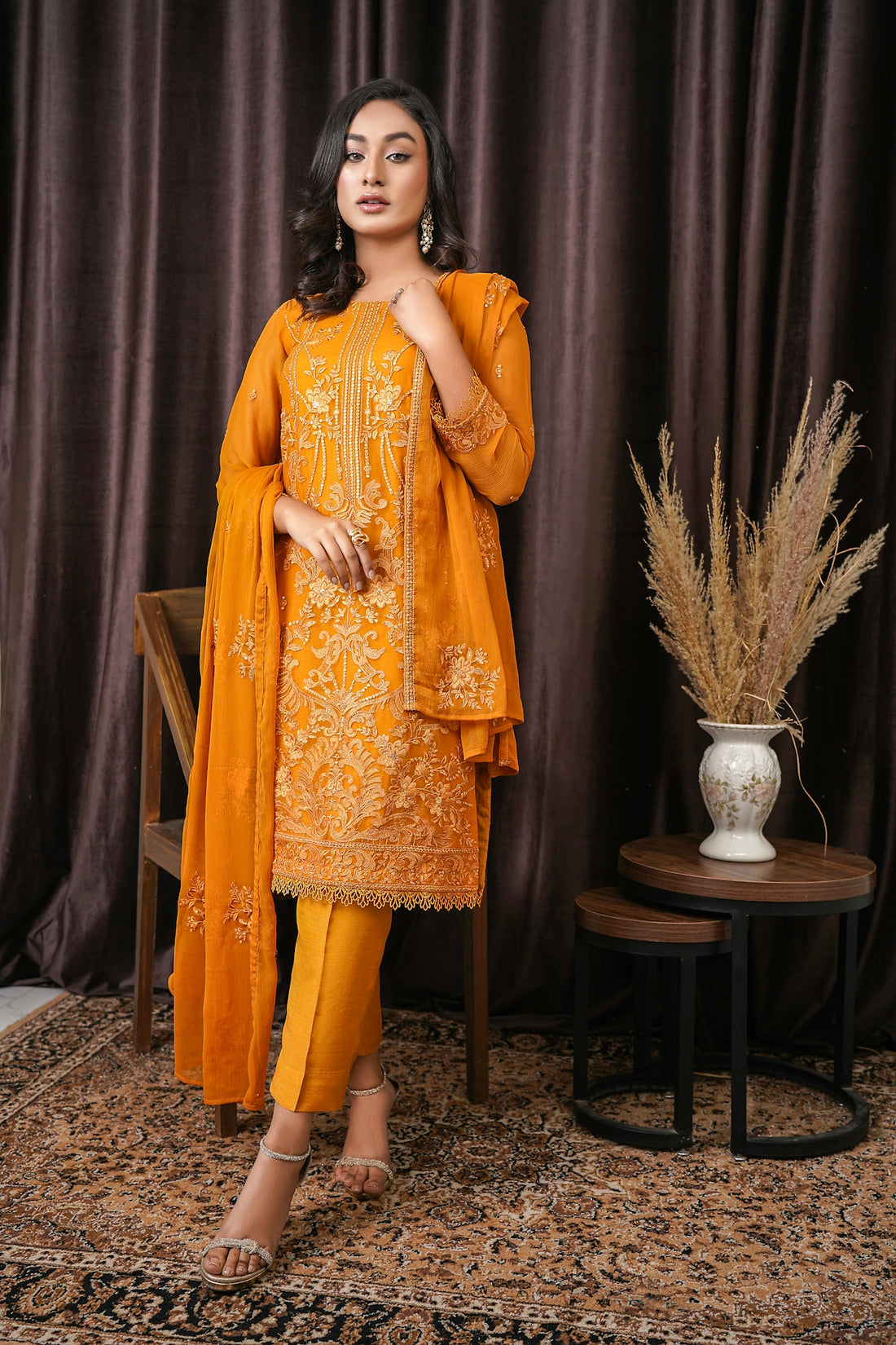 a woman standing in front of a brown curtain