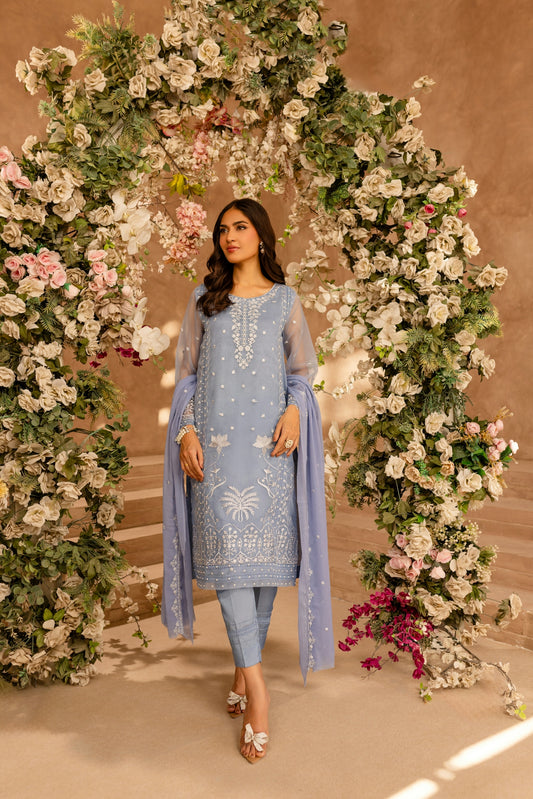 A woman standing in front of a floral archway