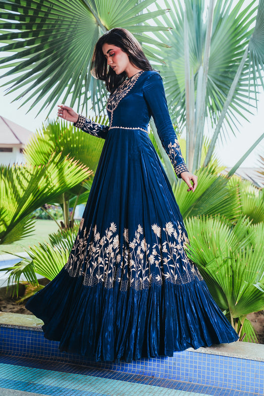 Woman in elegant blue gown with intricate embroidery
