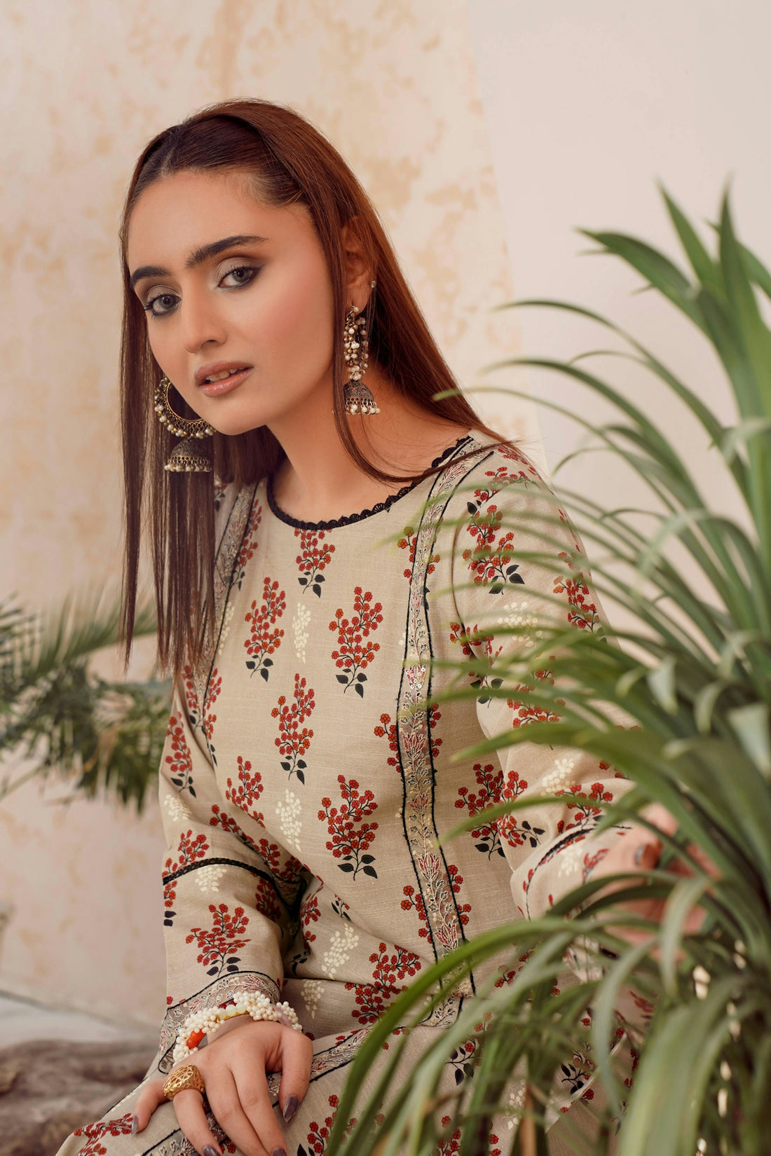 Young woman with patterned clothing and large earrings.